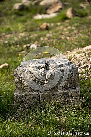 base of a very old stone column in a Greek ruins surrounded Stock Photo