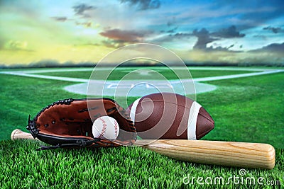 Baseball, bat, and mitt in field at sunset Stock Photo
