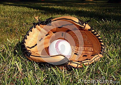 Baseball and glove in grass Stock Photo