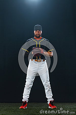 Baseball player on dark background. Ballplayer portrait. Stock Photo