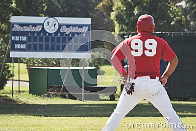 A baseball player on the pitch standing with his back towards camera with an empty scoreboard in the background Editorial Stock Photo