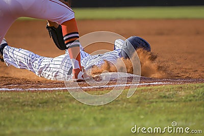 Baseball player sliding first base Stock Photo