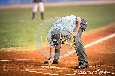 Baseball referee while cleaning the base Editorial Stock Photo