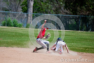 Teenage baseball shortstop tagging player out at second base. Stock Photo