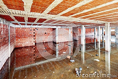 The basement of a building under construction filled with dirty flood water Stock Photo