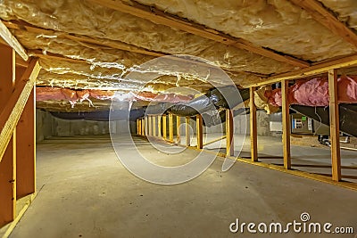 Basement or crawl space with upper floor insulation and wooden support beams Stock Photo