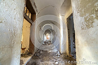 Basement of old fortress building, long narrow corridor with vaulted plastered ceiling and dirty floor Stock Photo
