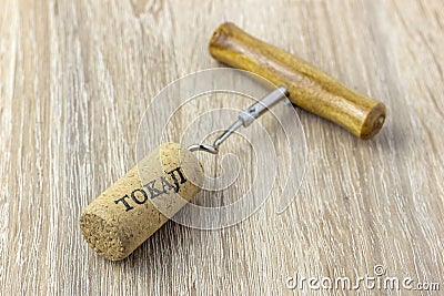 A basic corkscrew with a cork on a wooden table. Tokaji is wine`s name written on cork from Tokaj wine region Stock Photo