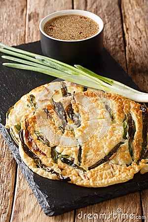 Basic recipe Pajeon Korean pancakes with green onions close-up on a slate board. vertical Stock Photo