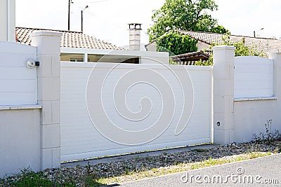 Basic simple white suburb metal aluminum house gate and slats street home Stock Photo