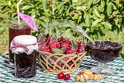 Basket of cherries, cherry jam with biscuit, cherry jam jar and glass of compote Stock Photo