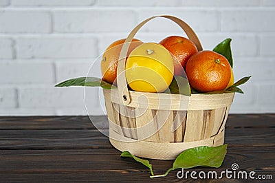 Basket with citrus fruits on a wooden surface Stock Photo