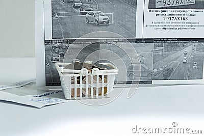 A basket of coins is a symbol of payment of a fine for a traffic violation. Russian text: identification of the state registratio Editorial Stock Photo