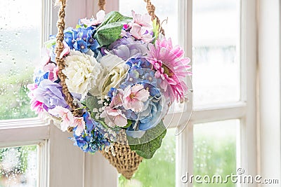 Basket of flower hanging on window Stock Photo