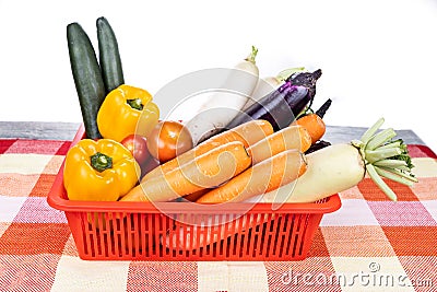 Basket of fresh assorted vegetables carrots, radish, capsicum, tomato, brinjal, cucumber Stock Photo