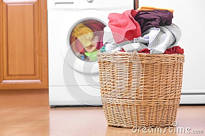 Basket with laundry and washing machine. Stock Photo