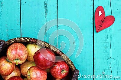 Basket of red apples on wood table with red heart Stock Photo