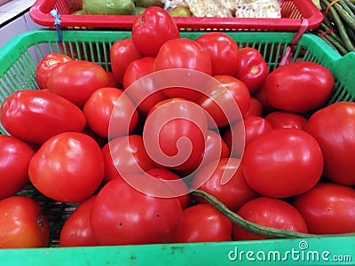 A basket of red tomatoes display for sale at grocery store Stock Photo