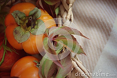 basket with ripe orange persimmons. beautiful background texture. juicy fruits. vitamins Stock Photo