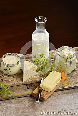 Basket with tasty organic dairy products on wooden table, Stock Photo