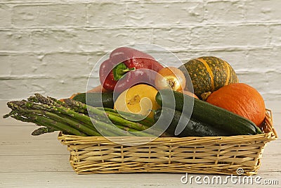 In a basket there are courgettes, carrots, pumpkins, peppers, onions and asparagus from the garden Stock Photo