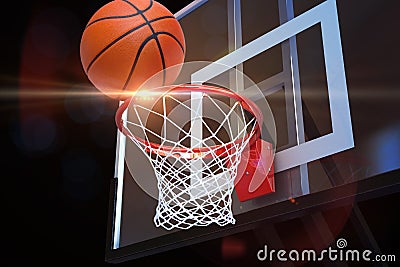 Basketball heading to the net at a sports arena with lens flare . Stock Photo