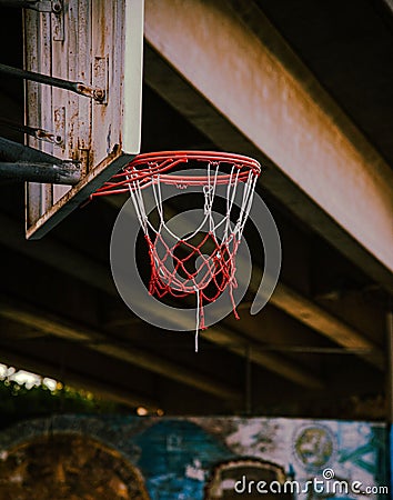 Basketball hoop hangs from the side of a building, the rim of the hoop visible against the wall. Stock Photo