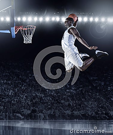 Basketball Player scoring an athletic, amazing slam dunk Stock Photo