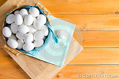 Basketful of fresh white eggs with one outside Stock Photo