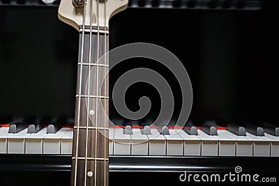 Bass guitar against grand piano keys Stock Photo