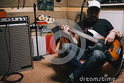 Bass guitarist with guitar in garage studio Stock Photo