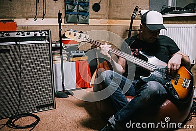 Bass guitarist playing guitar in music studio Stock Photo
