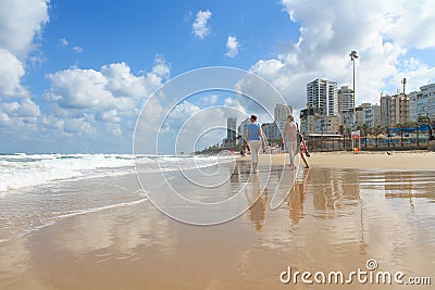 Bat Yam, Israel - 14 July, 2014. Tourists walking on the sandy beach Editorial Stock Photo