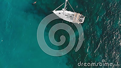 Bateau à voile sur l'eau turquoise. Les vacanciers à proximité nagent. Tir aérien banque de vidéos Bateau à voile sur l'eau turquoise. Les vacanciers à proximité nagent. Tir aérien banque de vidéos