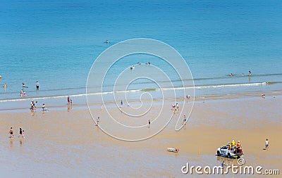 Bathers enjoy the warm blue sea,under the watchful eye of RNLI lifeguards Editorial Stock Photo