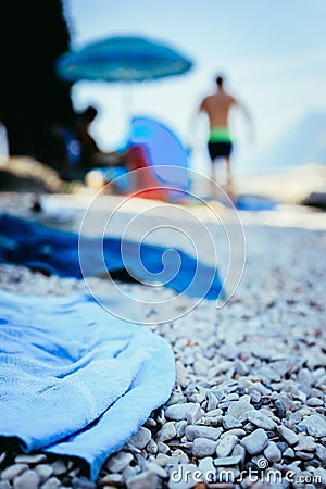 Bathing towel on the beach, other people in blurry background Stock Photo