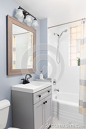 A bathroom detail with a grey cabinet and white hexagon tile floor. Stock Photo