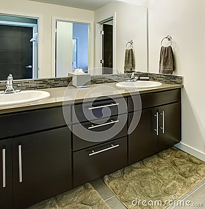 Bathroom interior with black cabinets, two sinks and large mirror. Stock Photo