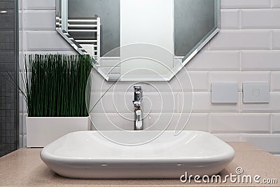 Bathroom interior. Bright bathroom with new tiles. New washbasin, white sink and large mirror. Stock Photo