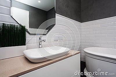Bathroom interior. Bright bathroom with new tiles. New washbasin, white sink and large mirror. Stock Photo