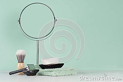 Bathroom interior in mint menthe with accessories for shave in black - razor, round mirror, soap, cotton towel, shaving brush. Stock Photo