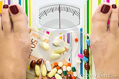 Bathroom scale with pills and money Stock Photo