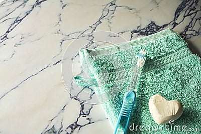 Close up blue washcloth, soap and toothbrush on marble plate Stock Photo