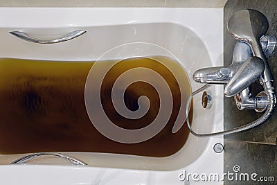 A bathtub filled with dirty water due to a clogged sewer pipe, close-up Stock Photo