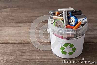 Battery recycle bin with old element on wood table. Stock Photo