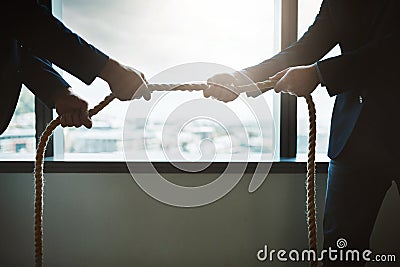 The battle of the business greats. two businessmen pulling on a rope in a game of tug of war. Stock Photo