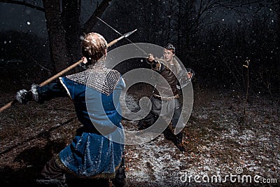 The battle between medieval knights in the style of Game of Thrones in winter forest landscapes. Spear against sword Stock Photo