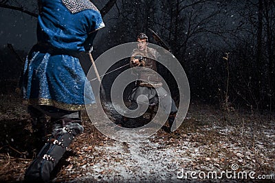 The battle between medieval knights in the style of Game of Thrones in winter forest landscapes. Spear against sword Stock Photo