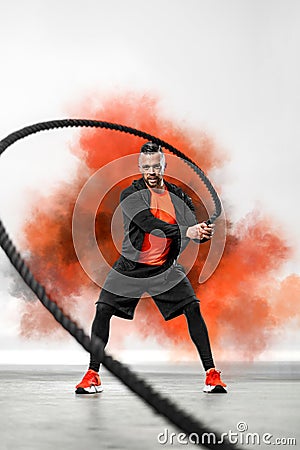 Battle rope functional training. Man on cross exercises. Fit athletic man doing fitness outdoors. Stock Photo