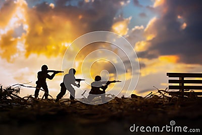 Battlefield with silhouettes of soldiers at sunset, toy military figurines of soldiers, concept of armed conflict and war, Ukraine Stock Photo